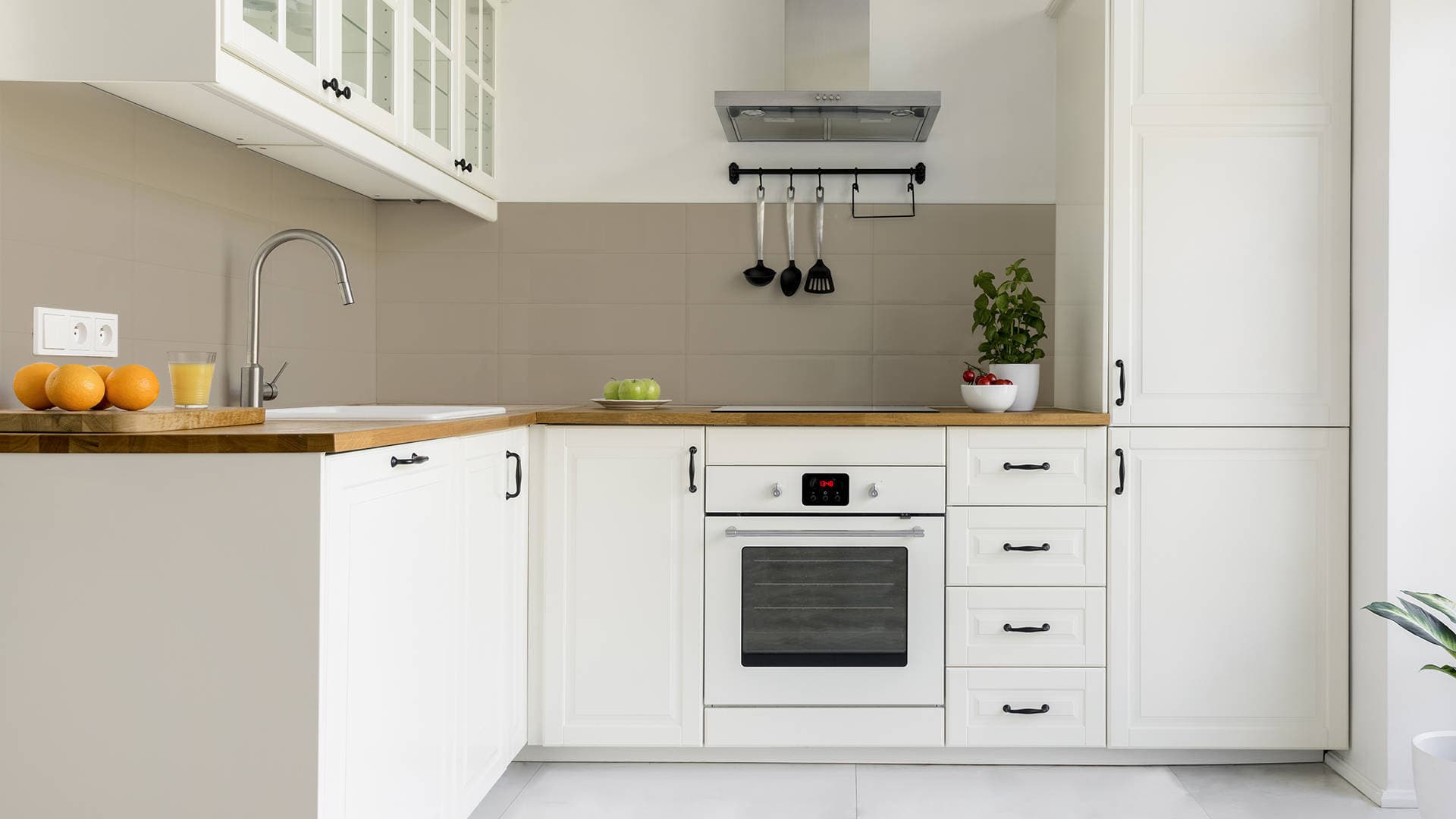 L-shaped kitchen with painted tiles on wall