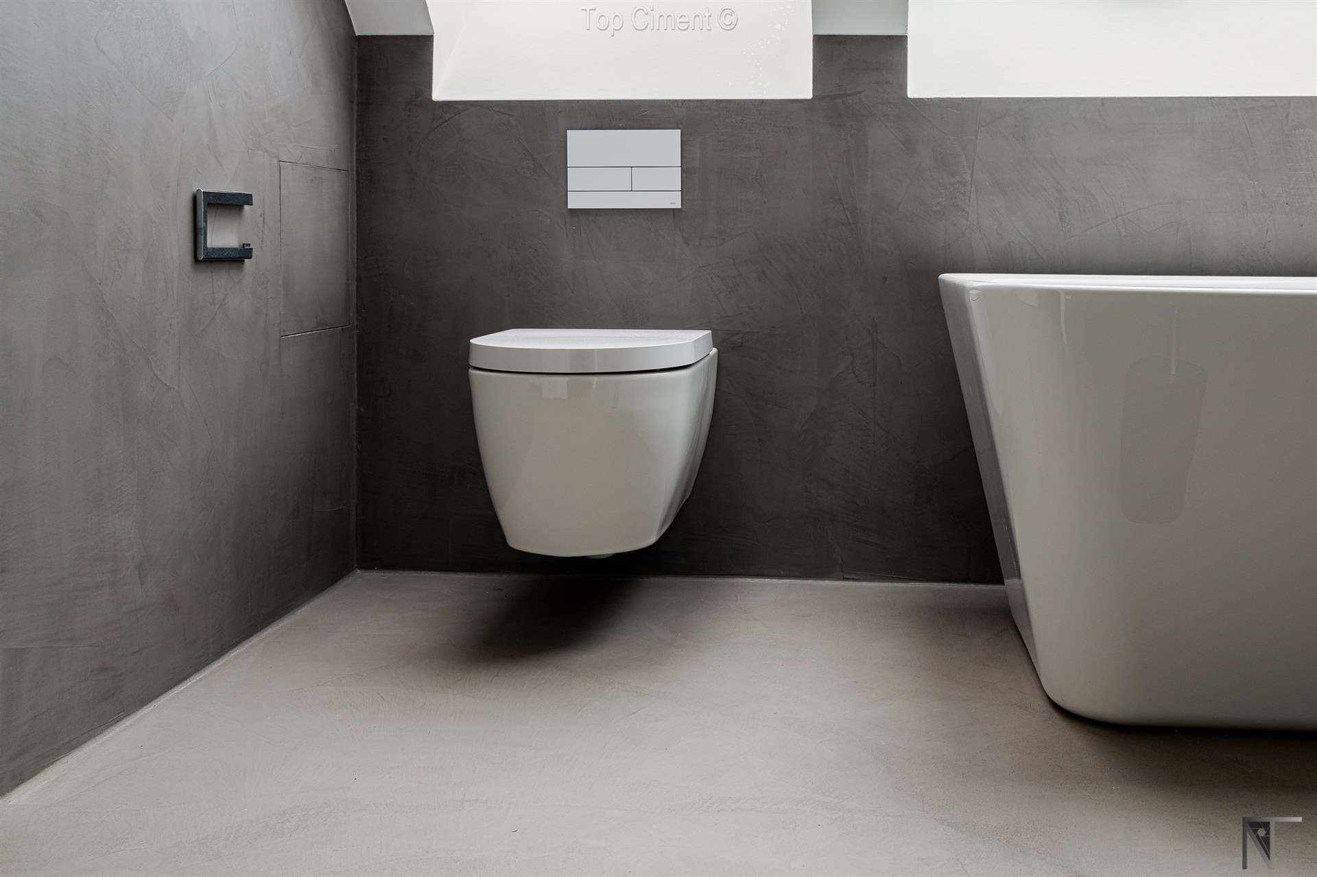 Salle de bain en carrelage rénovée avec du microciment gris sur les murs et le sol