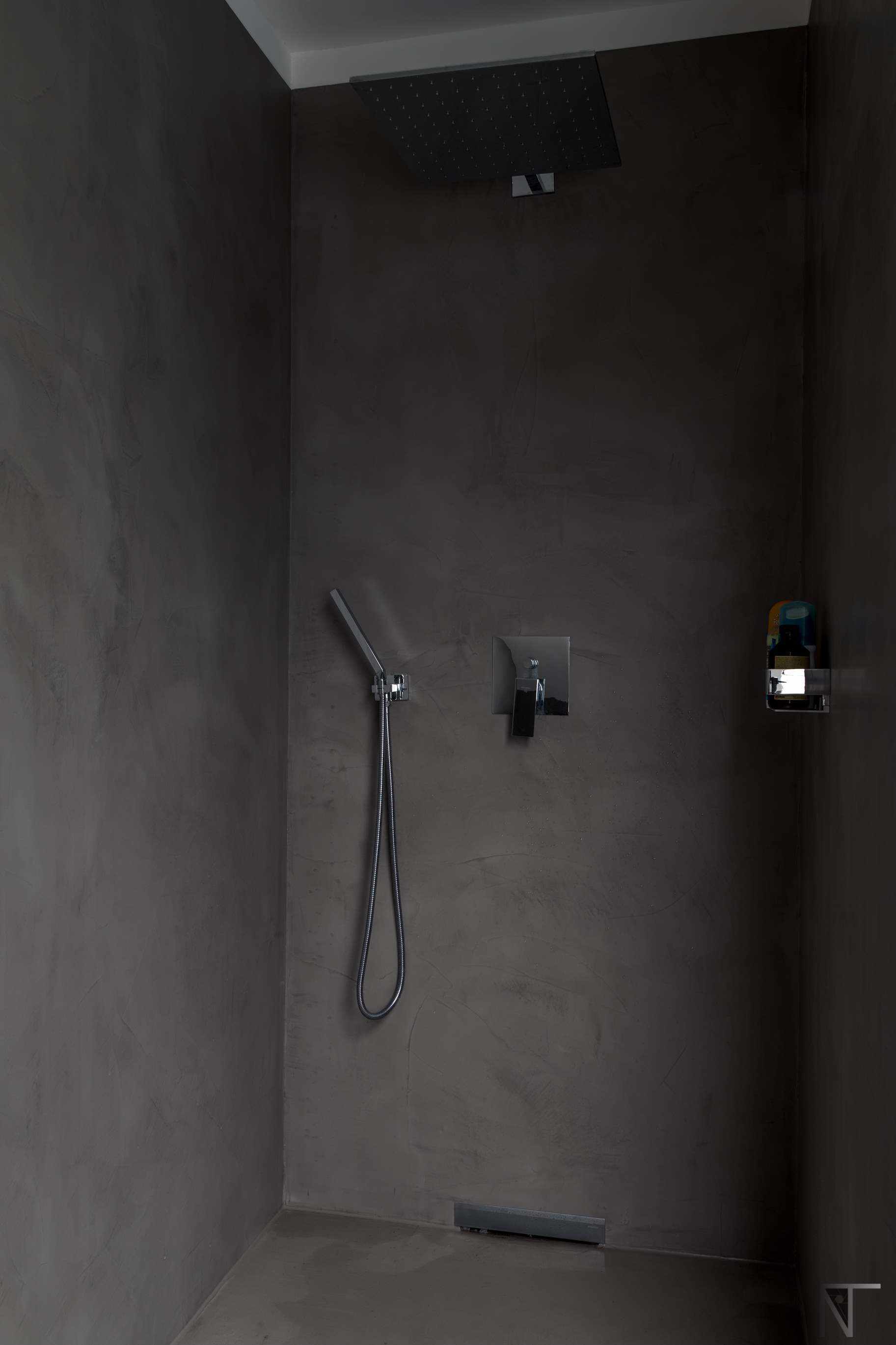 Salle de bain en carrelage rénovée avec du microciment dans la douche