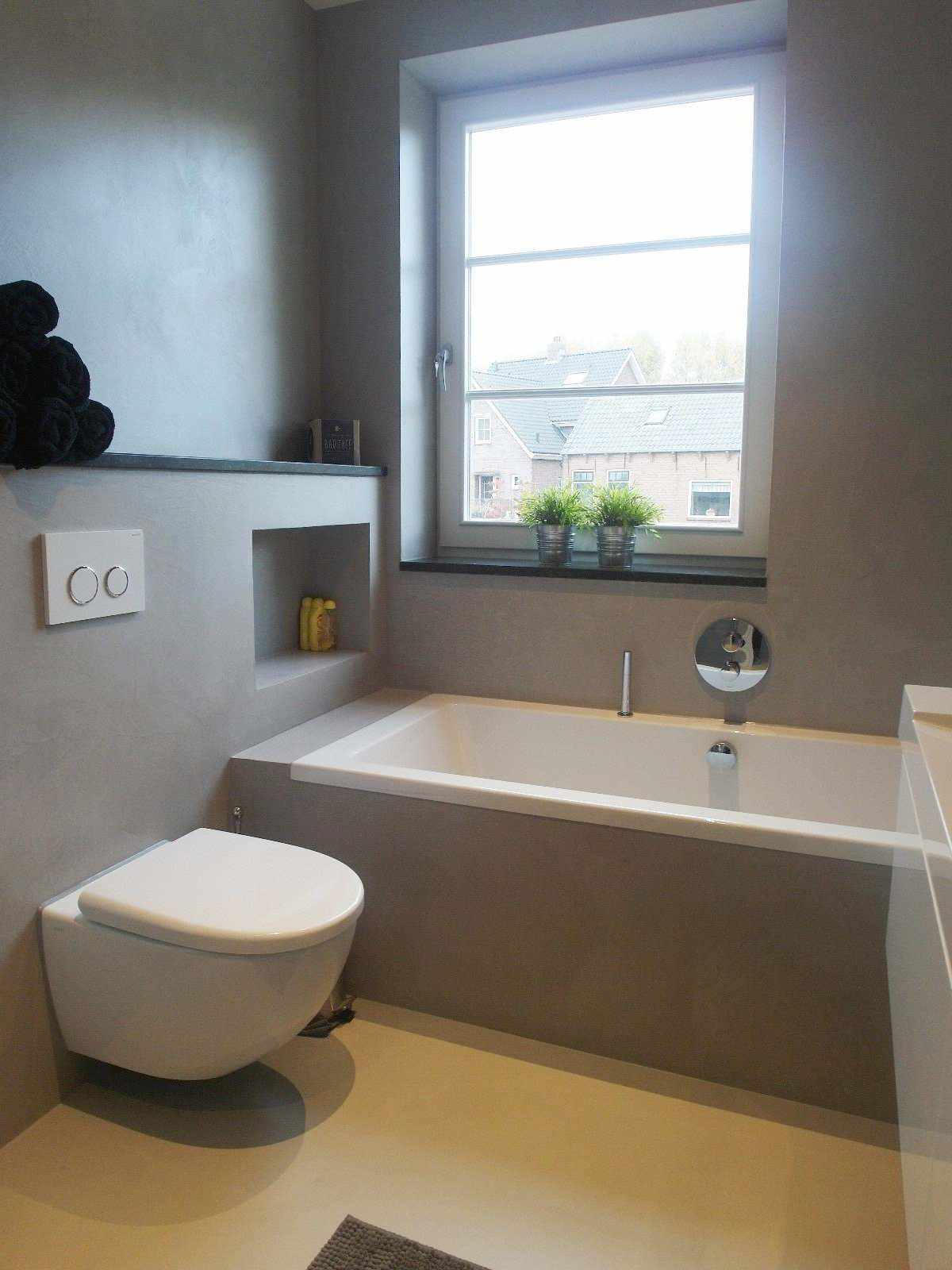 Siva mikrocementna stena in pohištvo v kopalnici na Nizozemskem v projektu Decas.
